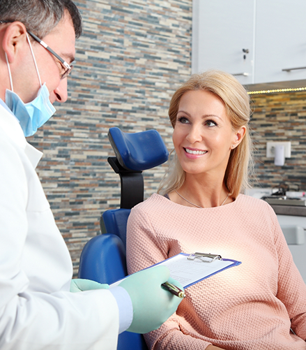 Woman in dental chair listening to her dentist talk