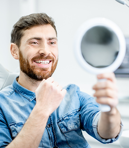 Dental patient looking at his smile in a mirror