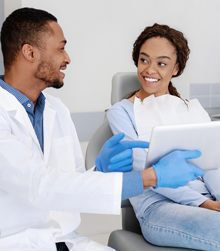 Woman in dental chair listening to her cosmetic dentist