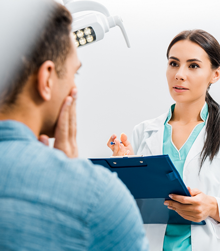 Emergency dentist listening to a patient with a toothache