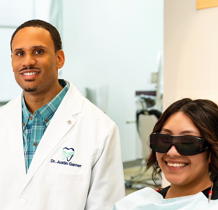 Independence dentist Doctor Justin Garner smiling next to a patient in the dental chair