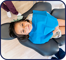 Young girl in dental chair looking up to the camera