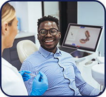 Man in dental chair grinning at his dentist