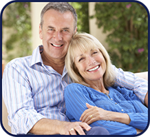 Older couple sitting and smiling outdoors