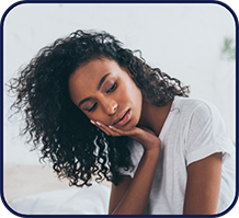 Woman wincing and holding her cheek in pain