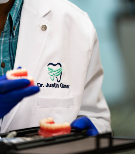 Doctor Justin Garner holding a set of dentures