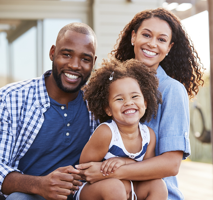 Family of three smiling after receiving dental services in Independence