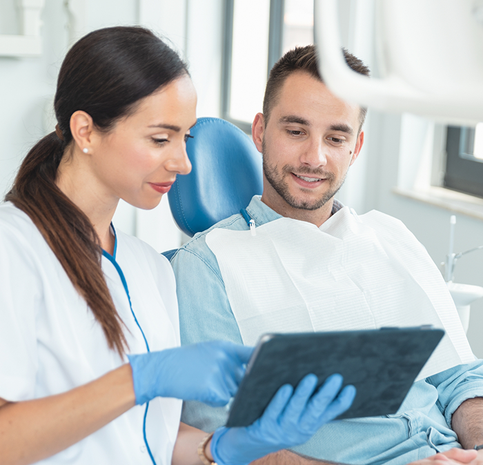 Dentist showing a patient a tablet screen during a preventive dentistry checkup