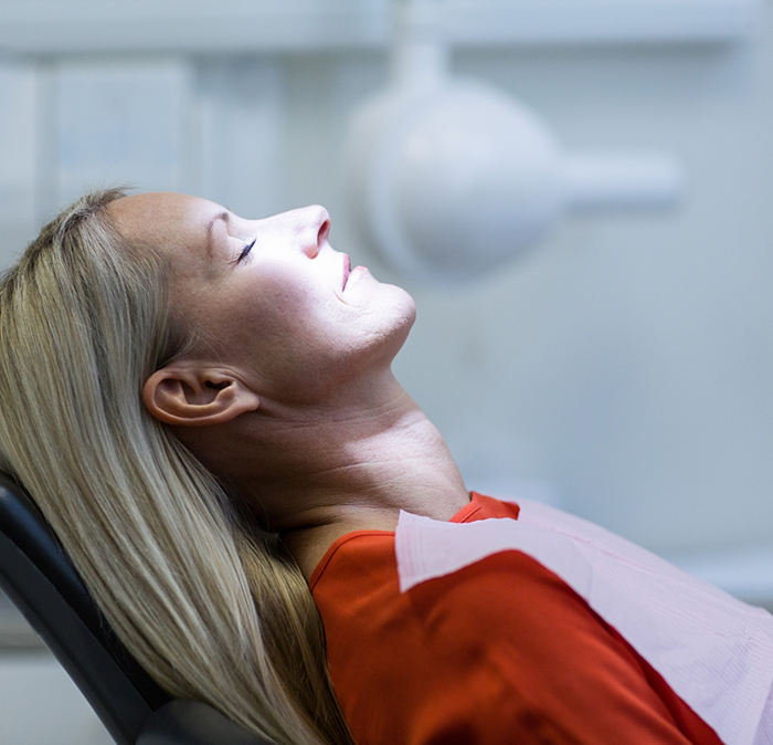 Woman relaxing in dental chair thanks to sedation dentistry in Independence